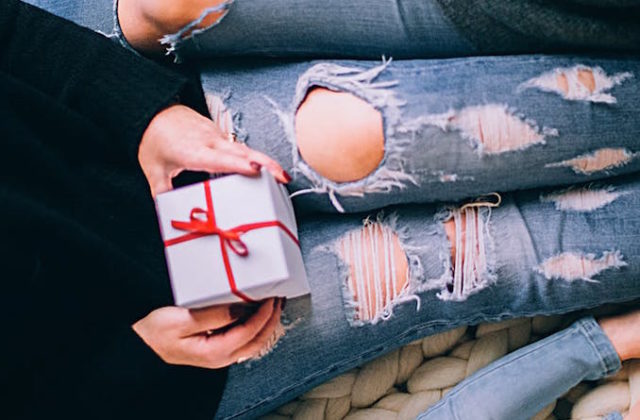 Woman sits with a Christmas present in her lap