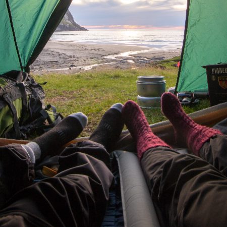 A photo of people's feet looking out the front door of a tent
