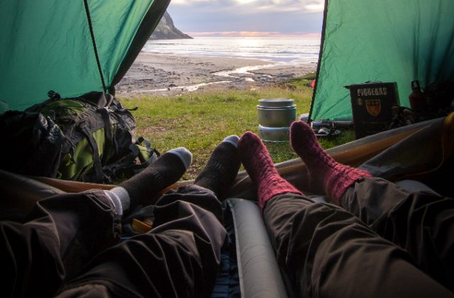 A photo of people's feet looking out the front door of a tent