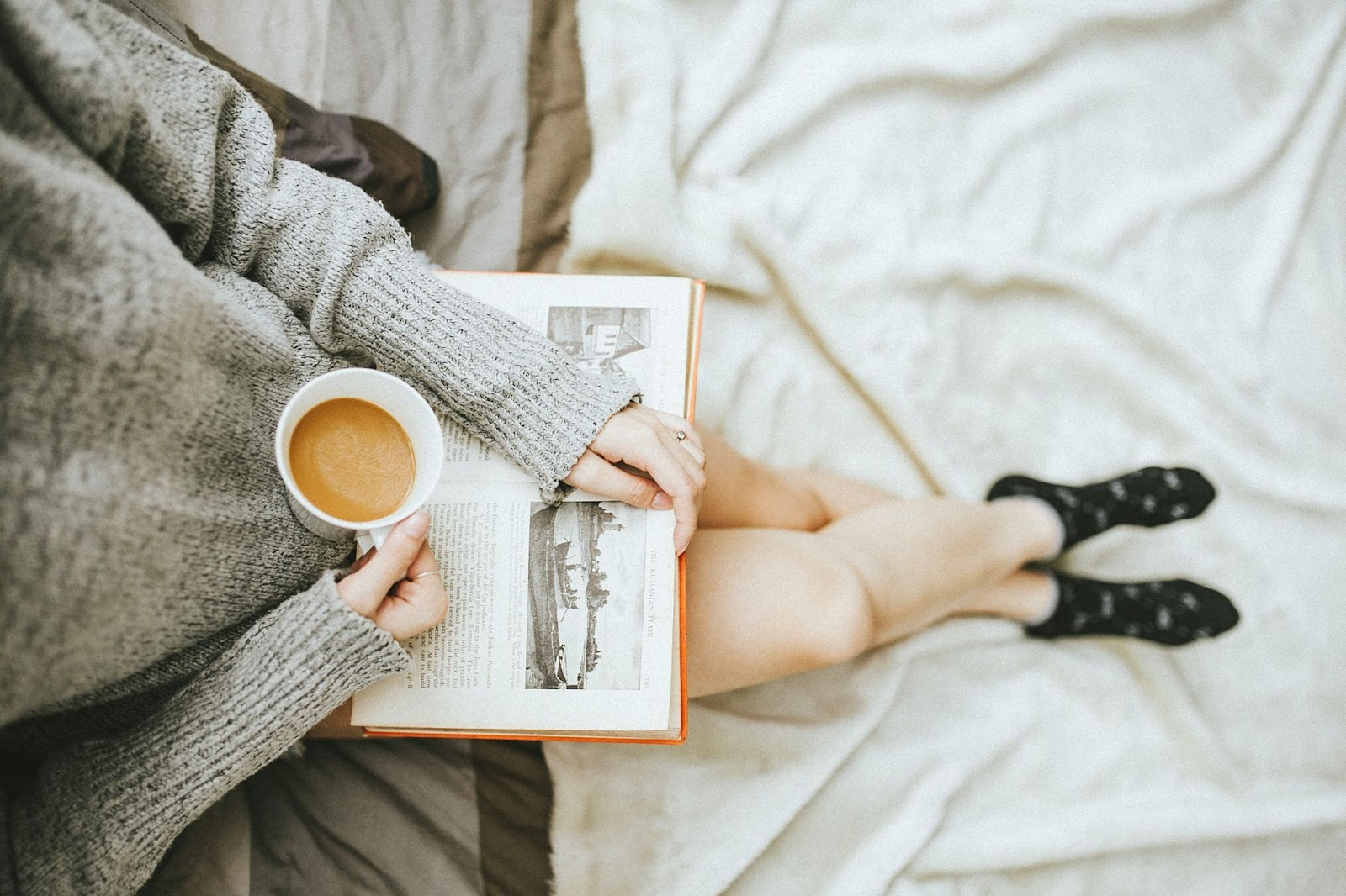 Woman reading book and drinking tea